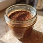 Close-up of rich chocolate overnight oats in a glass mason jar, ready to eat.