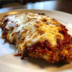 Close-up of a golden-brown breaded chicken breast topped with melted mozzarella and marinara sauce for Easy Chicken Parmesan.