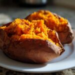 Two halves of a perfectly baked sweet potato, showing fluffy orange interior.
