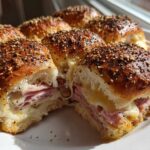 Close-up of gooey Ham and Cheese Sliders with melted cheese and everything bagel seasoning on top.