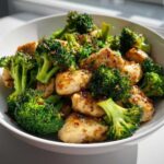 Close-up of tender chicken pieces and bright green broccoli florets coated in a savory sauce, featuring amazing chicken and broccoli.