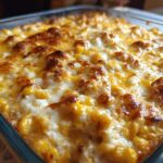 Close-up of baked corn dip with cream cheese, featuring golden brown, bubbly cheese topping.