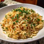 Close-up of perfectly cooked, fluffy rice pilaf garnished generously with chopped fresh parsley.