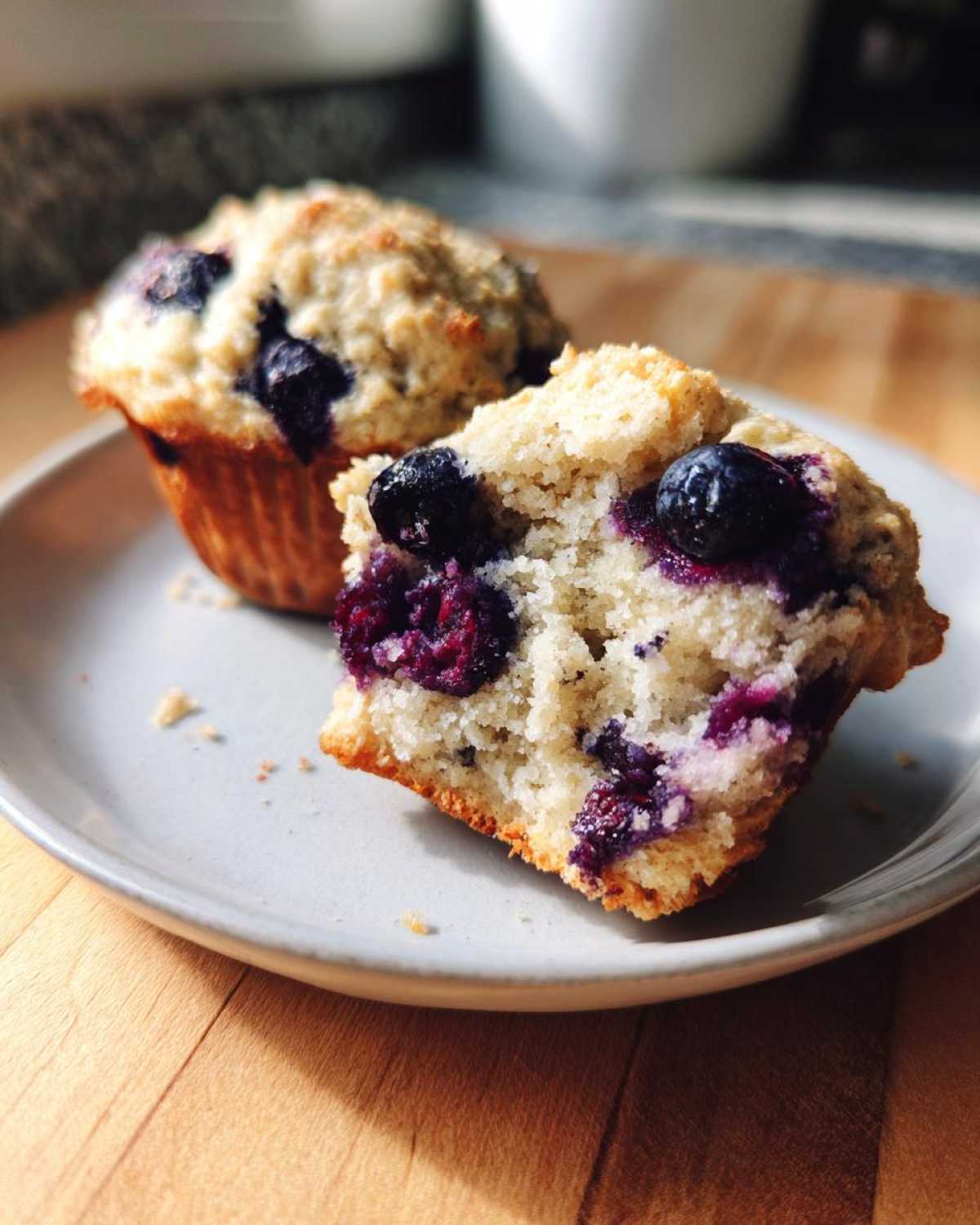 Close-up of a blueberry protein muffin cut in half showing the moist interior and whole berries.