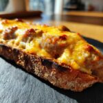 Close-up of a slice of toasted bread topped with melted, bubbly cheese mixture from the hanky panky recipe.