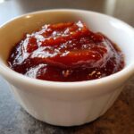 Close-up of thick, rich, homemade bbq sauce served in a small white ramekin.