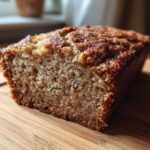 Close-up of a moist slice of sugar free banana bread showing the crumb texture and caramelized top.