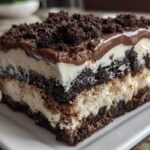 Close-up of a layered slice of no-bake Oreo dirt cake showing chocolate cookie layers and cream filling.
