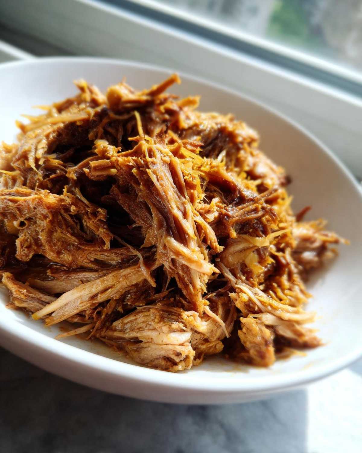 Close-up of tender, shredded pork meat, ready to be served with pork and sauerkraut.
