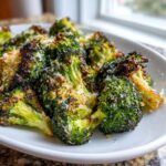 Close-up of perfectly roasted broccoli florets topped with grated Parmesan cheese.