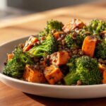 Close-up of a bowl featuring roasted sweet potato chunks, bright green broccoli florets, and brown lentils in a veggie lentil salad.