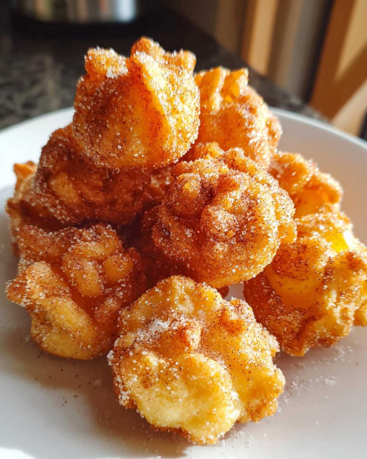 Close-up of golden brown Air Fryer Cinnamon Sugar Churro Bites piled high and coated in sugar.
