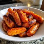 Close-up of sweet, caramelized Air Fryer Maple Glazed Carrots piled high in a white serving bowl.