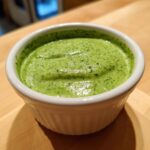Close-up of vibrant green Copycat Panera Green Goddess Dressing served in a small white ramekin.