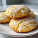 A stack of four moist Gluten-Free Lemon Ricotta Cookies drizzled with white lemon glaze and lemon zest.