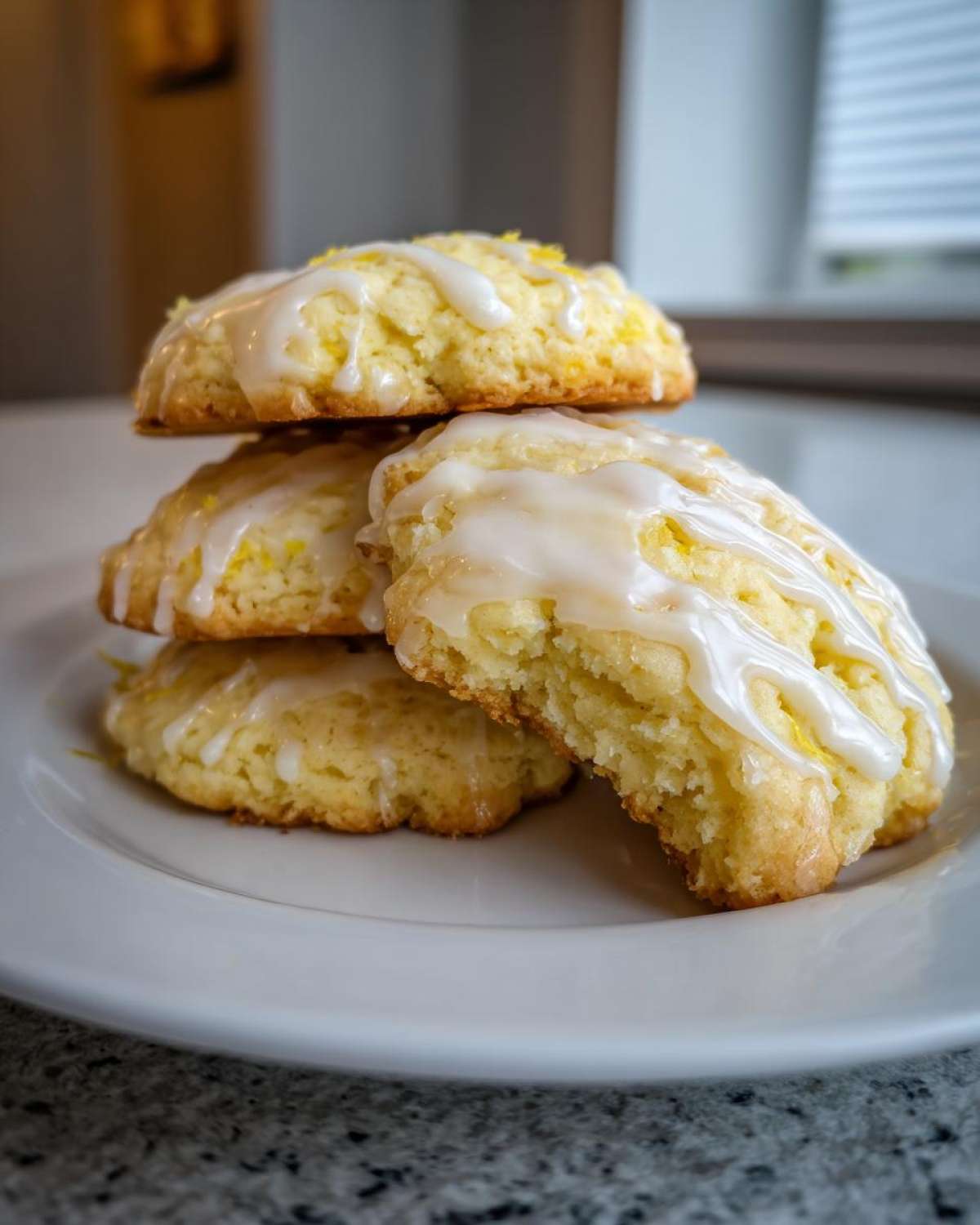 A stack of four moist Gluten-Free Lemon Ricotta Cookies drizzled with white lemon glaze.
