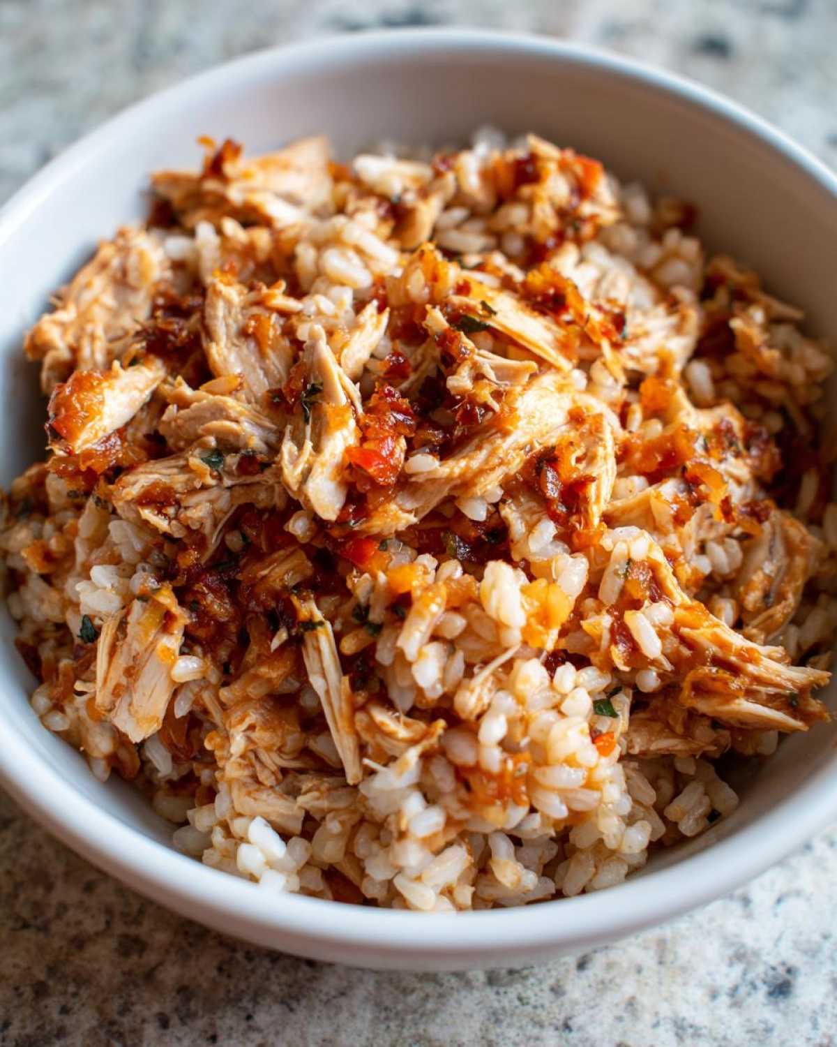 Close-up of Instant Pot Chicken Burrito Bowls with brown rice and shredded seasoned chicken.