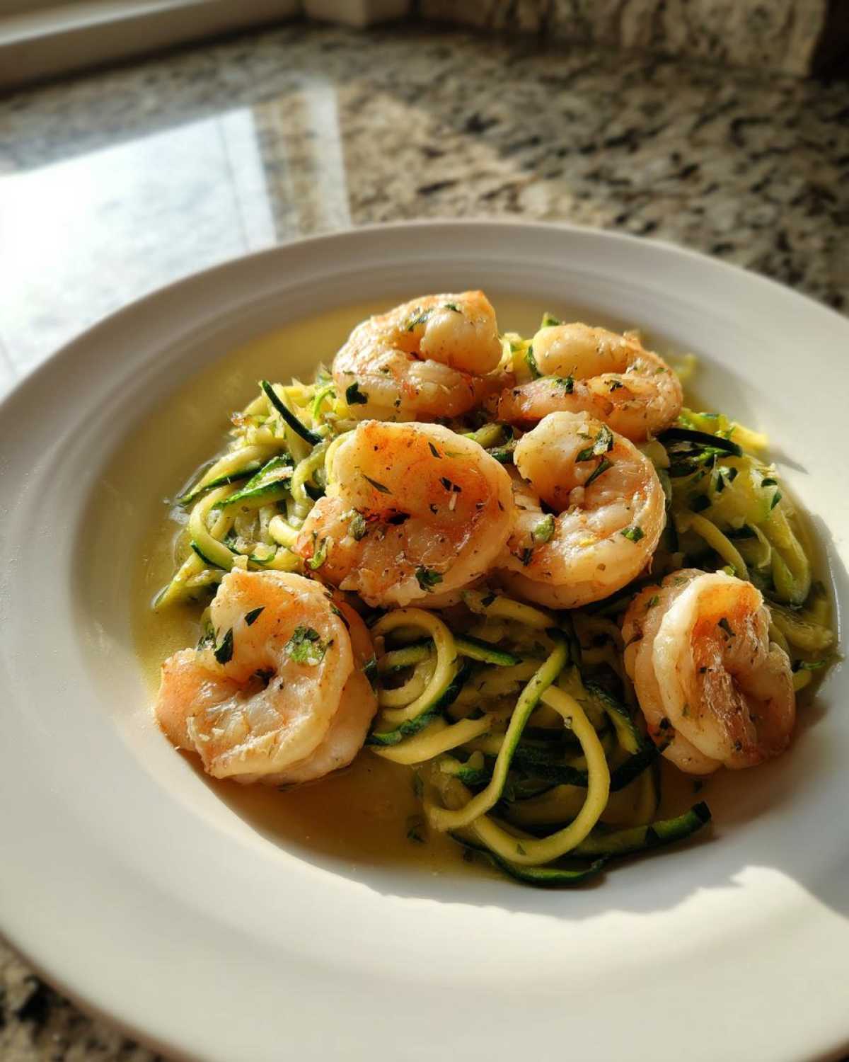 Close-up of Keto Shrimp Scampi Zucchini Noodles served in a white bowl with buttery garlic sauce.