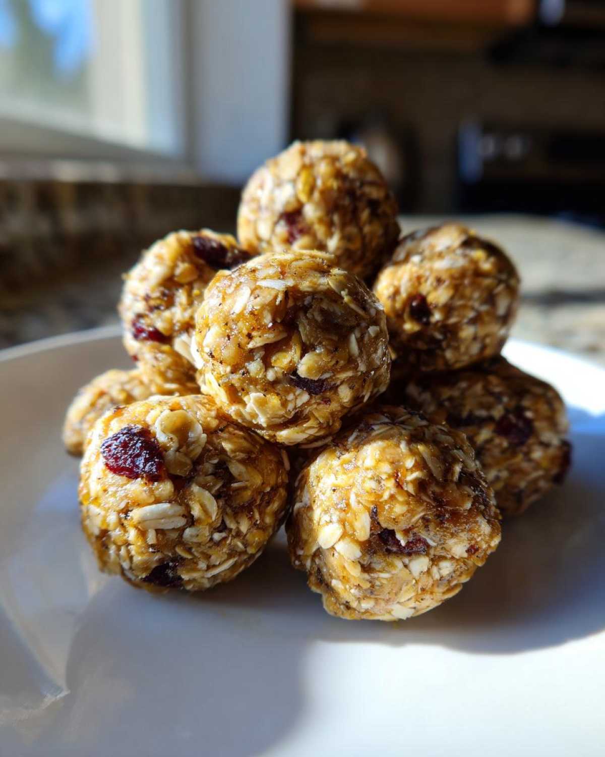 Close-up of several No-Bake Lemon Blueberry Energy Bites stacked on a white plate.