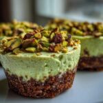 Close-up of a No-Bake Pistachio Cheesecake Cup with a thick crust and topped with chopped pistachios.