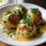 Four One-Pan Creamy Garlic Butter Chicken Meatballs smothered in rich sauce and topped with fresh parsley.