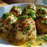 Close-up of One-Pan Creamy Garlic Butter Chicken Meatballs garnished with fresh parsley in a rich sauce.