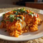 A serving of One-Pot Creamy Tomato Basil Chicken and Rice topped with fresh basil.