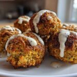 Close-up of golden brown Air Fryer Herb Falafel Balls stacked on a white plate, generously drizzled with creamy tahini sauce.