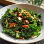 A close-up of the Copycat Kale Crunch Salad, featuring vibrant green kale tossed with crunchy almonds and dressing.