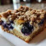 Close-up of a square slice of Easy Sheet Pan Blueberry Streusel Pancake with a thick streusel topping and creamy filling.