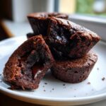 Close-up of Gluten-Free Chocolate Lava Brownie Cups, one broken open revealing a molten chocolate center.