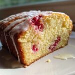 Close-up of a slice of moist Gluten-Free Strawberry Lemon Pound Cake topped with a white lemon glaze.