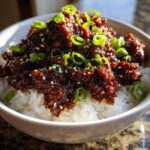 A close-up of Instant Pot Korean Beef and Rice Bowls topped with sesame seeds and fresh green onions.