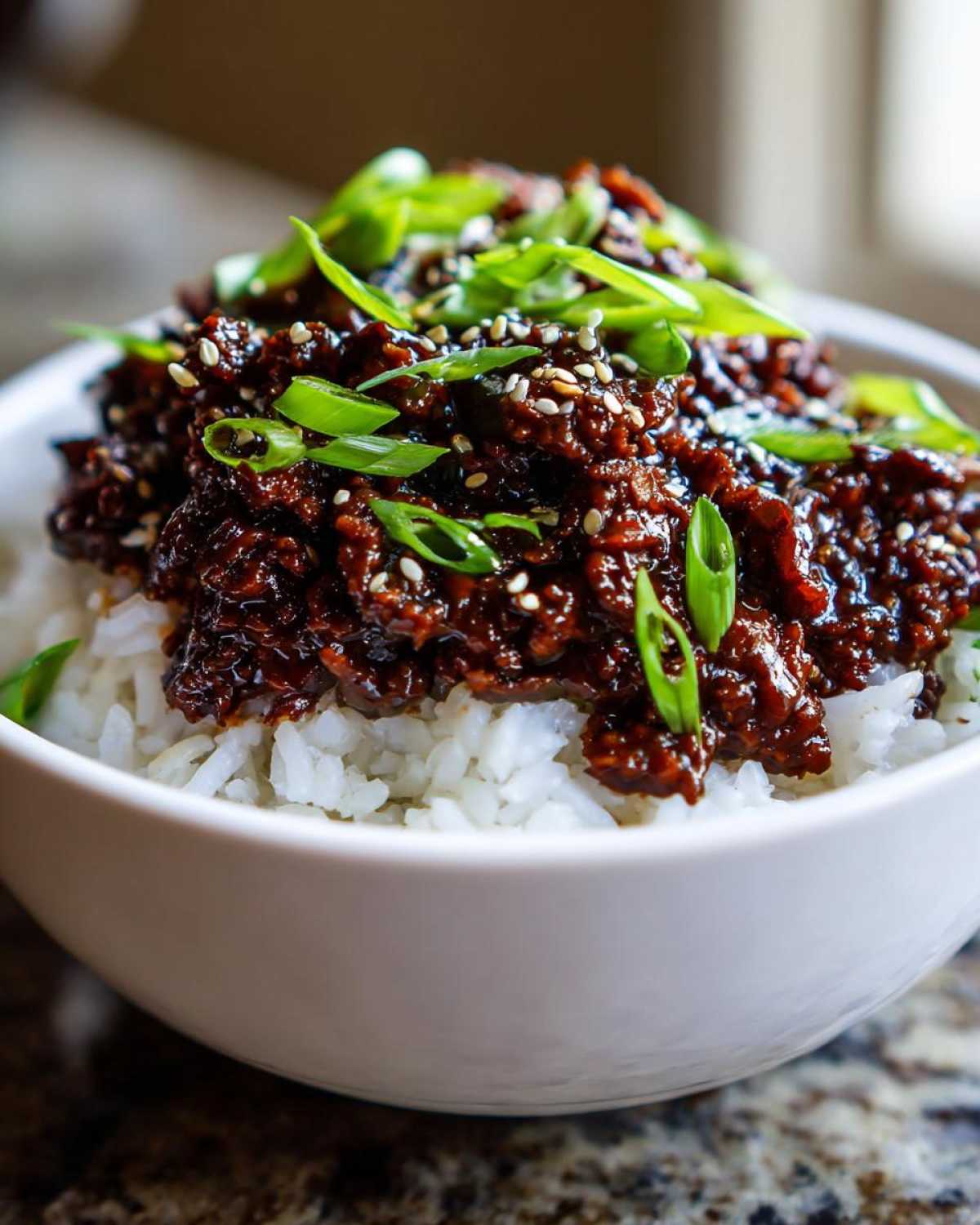 Close-up of Instant Pot Korean Beef and Rice Bowls topped with sesame seeds and green onions.