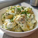 Close-up of Keto Creamy Herb Deviled Egg Salad chunks mixed with creamy dressing and fresh dill and chives.