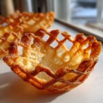 Close-up of a single, golden-brown, crispy Keto Crispy Cheese Taco Shell Bowl with a lattice edge.