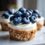Close-up of a No-Bake Blueberry Cheesecake Oat Cup topped with creamy filling and fresh blueberries.