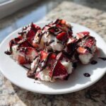 Close-up of several No-Bake Chocolate Strawberry Yogurt Clusters drizzled heavily with dark chocolate sauce.