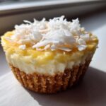 A close-up of one No-Bake Lemon Coconut Cheesecake Cup topped with shredded coconut.
