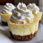 Close-up of a No-Bake Lemon Cream Pie Cup featuring a graham cracker crust, creamy lemon filling, and a swirl of whipped cream.