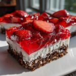 Close-up of a layered No-Bake Strawberry Pretzel Dessert Bars slice showing pretzel crust, cream cheese layer, and strawberry gelatin topping.