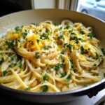 Close-up of One-Pot Creamy White Bean Lemon Pasta topped with fresh parsley and bright yellow lemon zest.