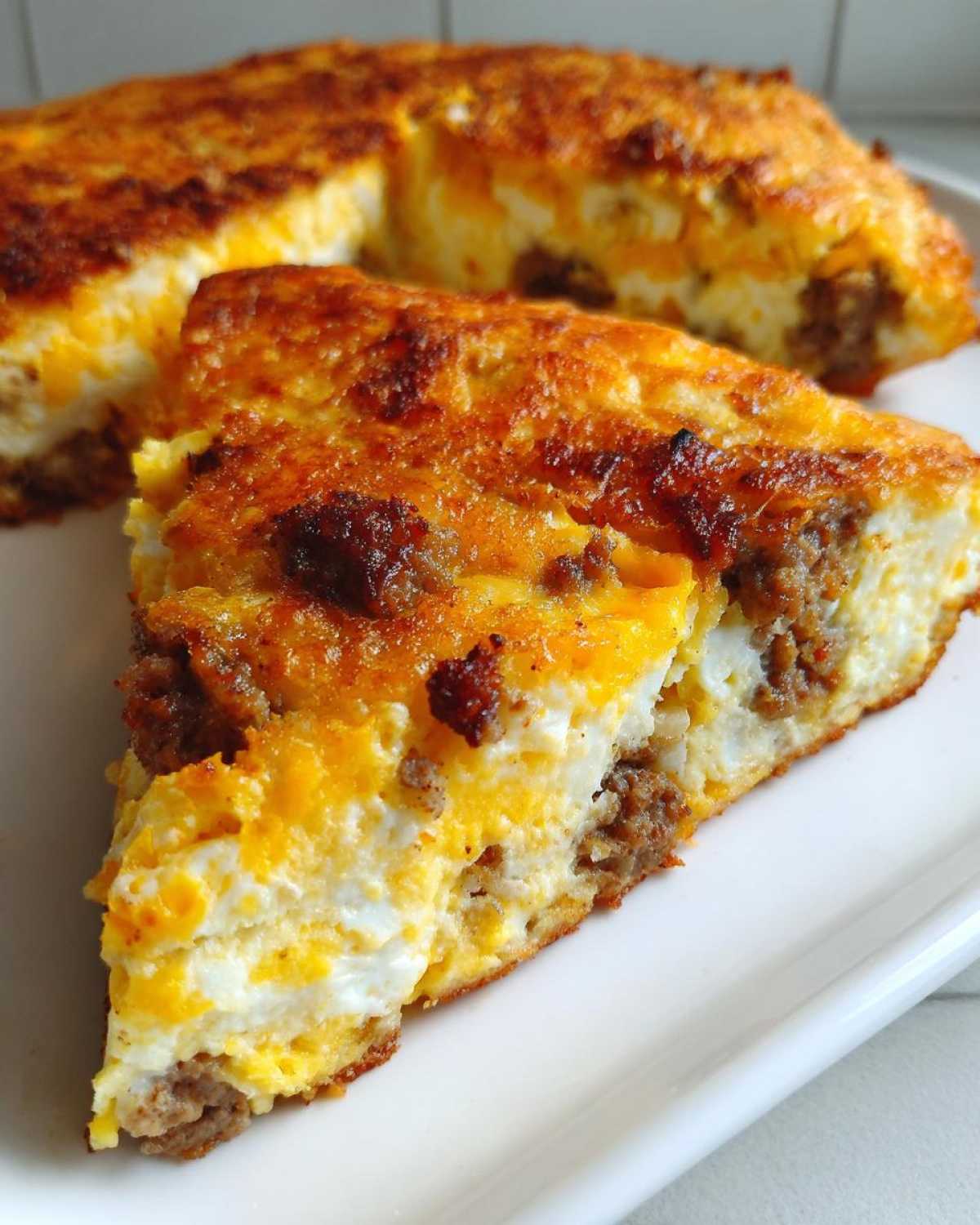 Close-up of a slice of Sheet Pan Breakfast Quesadillas showing eggs, cheese, and sausage filling.