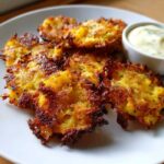 Close-up of crispy Sheet Pan Crispy Smashed Potatoes served golden brown with a side of creamy garlic aioli.
