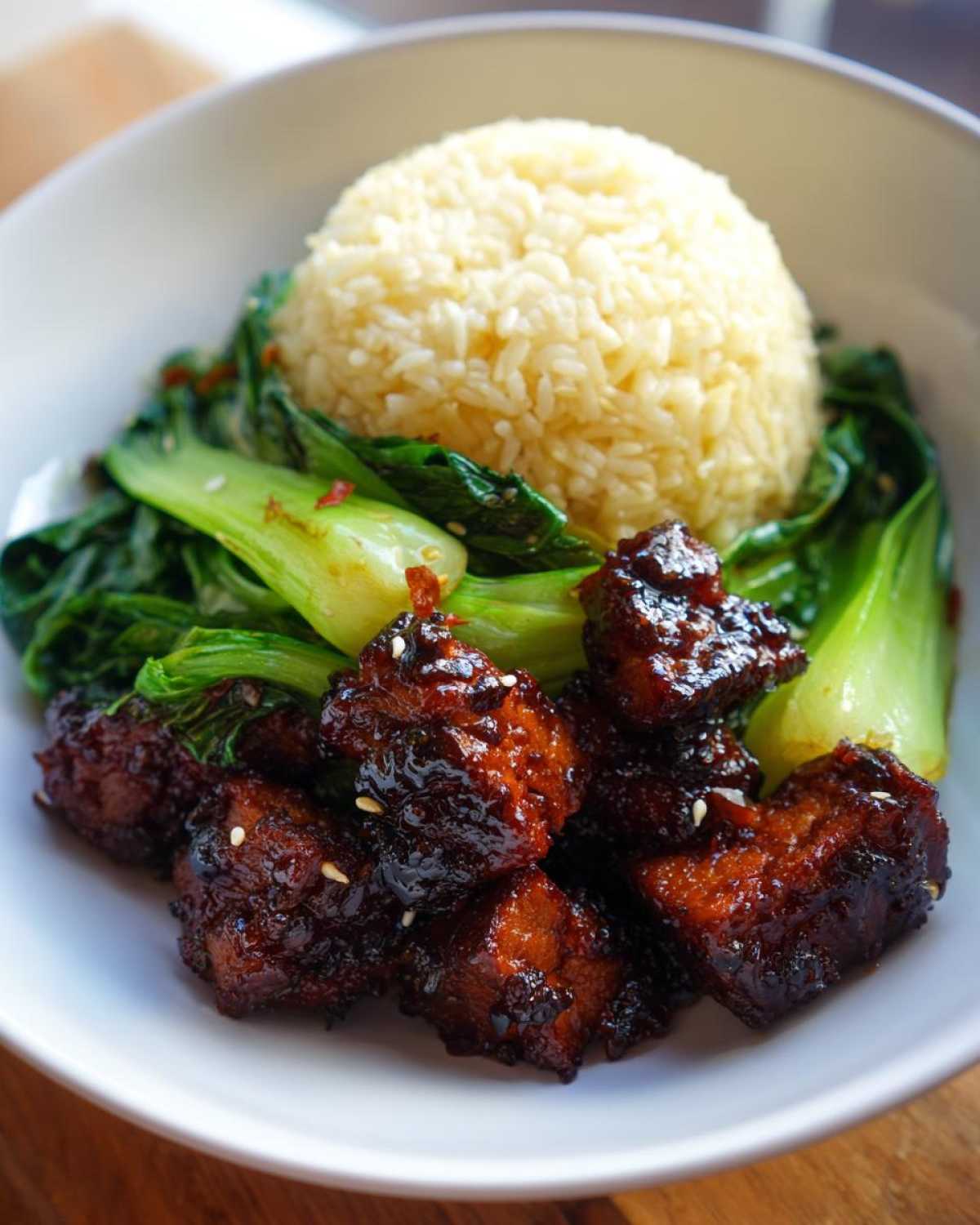 Close-up of a Vegan Crispy Sesame Tempeh Bowl featuring glazed tempeh cubes, steamed rice, and bright green bok choy.