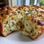 Close-up of freshly baked Cheese Bread with melted, stretching mozzarella and herbs on top.