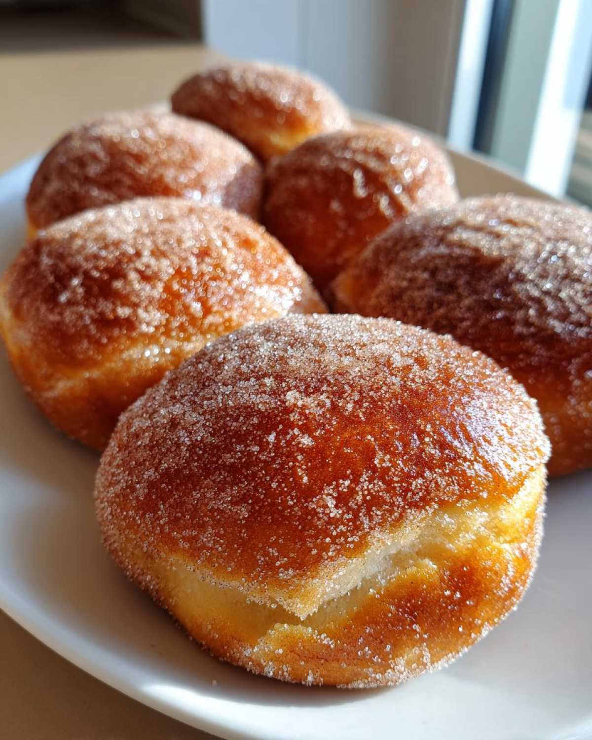 Close-up of several golden-brown Cinnamon Donut Bread pull-apart pieces generously coated in sparkling cinnamon sugar.
