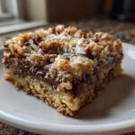Close-up of a square slice of Easy Coconut Pecan Chocolate Dessert bar on a white plate.