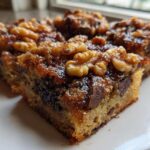 Close-up of Ooey Gooey Banana Bars Dessert squares topped with sticky glaze and walnuts.